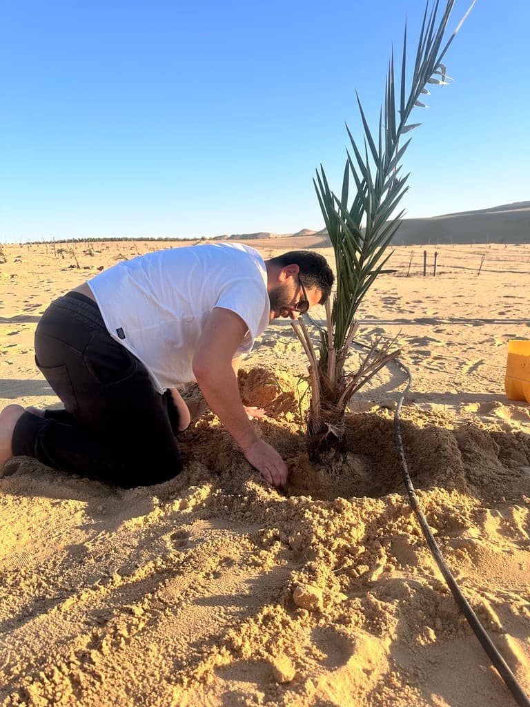 Hassan planting a palm on the LK Dunes land