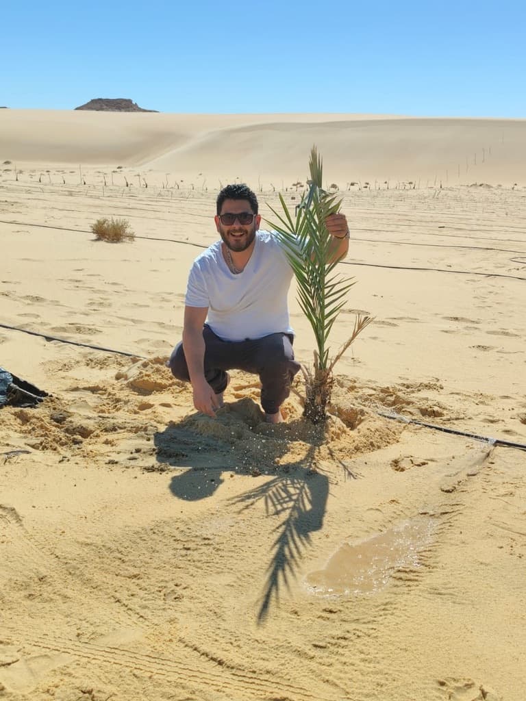 Hassan with a newly planted palm on the LK Dunes land